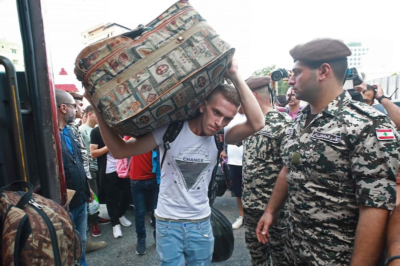 A Syrian man carries luggage as refugees prepare to leave Beirut. AFP