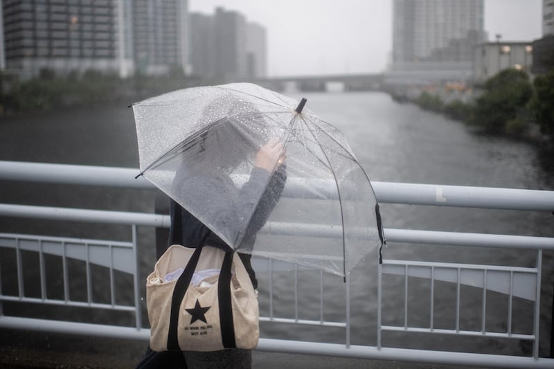 A woman protects herself from the rain with an umbrella in Tokyo.  AFP / Martin BUREAU