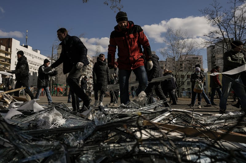 People clear debris outside a medical centre damaged by the same Russian missile after it was intercepted. AP