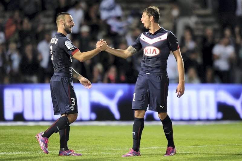 Bordeaux's Diego Contento (L) and Emiliano Sala (R) celebrate at the end of the French L1 football match Bordeaux (FCGB) vs Moncao (ASMFC) on August 17, 2014 at the Chaban Delmas Stadium in Bordeaux. Bordeaux won 4-1. AFP PHOTO / NICOLAS TUCAT (Photo by NICOLAS TUCAT / AFP)