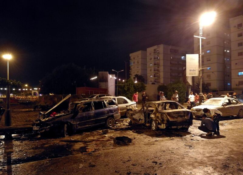 People look at the remnant of a car at the scene of a car bombing in Benghazi, Libya May 25, 2018.  REUTERS/Stringer