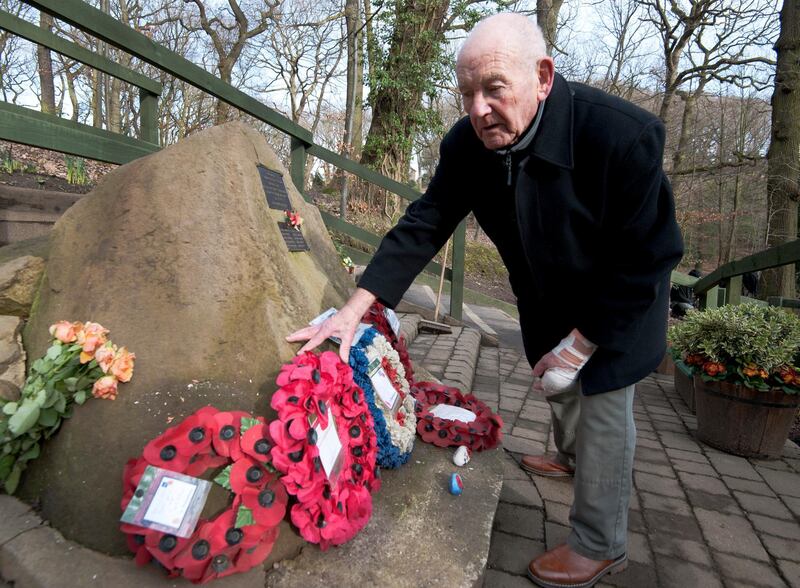 Tony Foulds tends to a memorial honouring the airmen. AP Photo