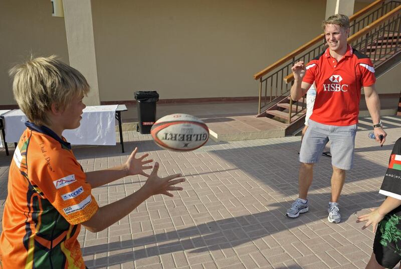 Tom Sherwood, of the Dubai Arabian Knights, left, and Lewis Moody pass the ball around. Jeff Topping for The National