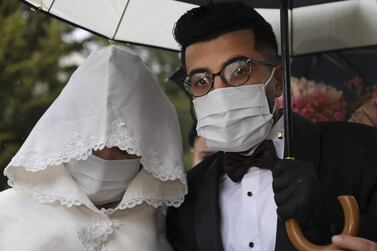Imad Sharaf accompanies his bride Baraa Amarneh as they arrive at their home in the village of Al Dahriya, south of Hebron in the West Bank, on March 20, 2020. The couple celebrated their wedding wearing masks and gloves as precautionary measures during the coronavirus pandemic. Guests were restricted to immediate family members. The Palestinian Authority said 48 cases of the disease had been identified in the West Bank. AFP