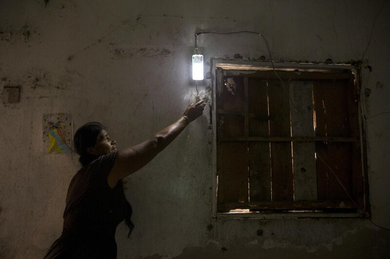 Norma Guerra, a participant in the Barefoot College program, opens a solar powered light she installed at her home in the town of Cachimbo, Oaxaca state, Mexico, on Wednesday, Feb. 14, 2018. Under a program, known as Barefoot College in Tilonia, India, designed to empower poor rural communities around the world, local women from Cachimbo went to India for six months to be trained as electrical technicians. They returned to install dozens of solar panels, battery packs and wiring that now run lights and appliances all over the village. Photographer: Yael Martinez/Bloomberg