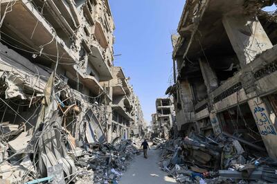 A Palestinian man walks amid the rubble after Israeli air strikes in Khan Yunis, southern Gaza, on Tuesday. AFP
