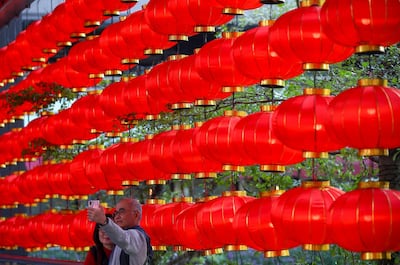 epaselect epa06527492 A chinese couple takes a seflie photo next to a Chinese New Year decoration in Taipei, Taiwan, 15 February 2018, as Taiwanese people prepare for the Chinese New Year which begins on 16 February. During the week-long holiday which is also called Spring Festival, which ushers in the Year of the Dog, Chinese people reunite with family members, visit friends and relatives, exchange gifts and set off fire crackers.  EPA/RITCHIE B. TONGO