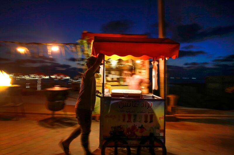 A Palestinan street vendor pushes his food cart along the seaside promenade in Gaza City. AFP