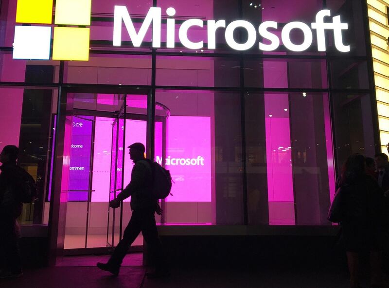 FILE - In this Nov. 10, 2016, file photo, people walk past a Microsoft office in New York. China-based government hackers have exploited a bug in Microsoft's email server software to target U.S. organizations, the company said Tuesday, March 2, 2021. (AP Photo/Swayne B. Hall, File)