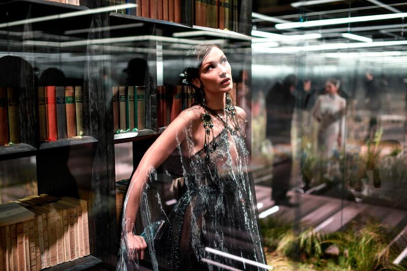 Bella Hadid poses in her glass box on the Fendi runway. AFP