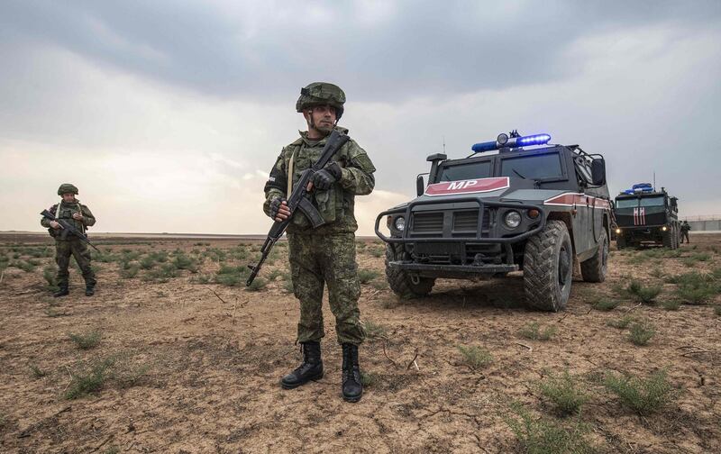 Russian sodier stand in front of military vehicles in the countryside of the town of Darbasiyah in Syria's northeastern Hasakeh province on the border with Turkey. AFP