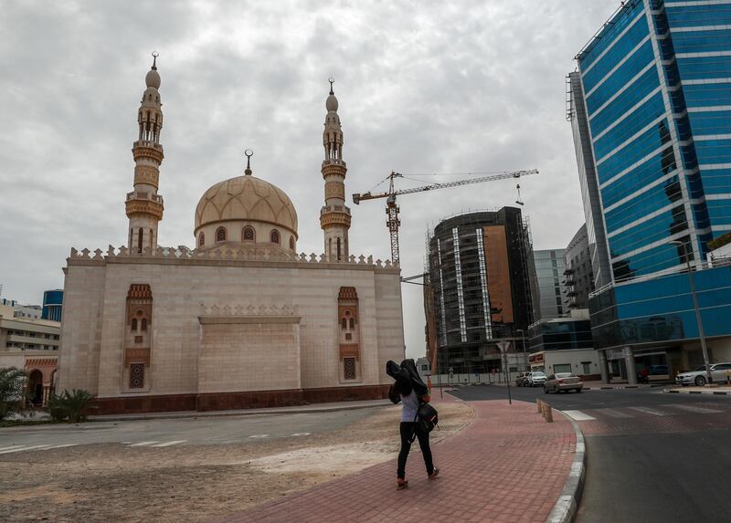 Dubai, U.A.E.,  A woman walks along the Sheikh Hamdan Mosque at Deira during overcast skies and gusty winds.
Victor Besa / The National.
Standalone for Jake Badger.