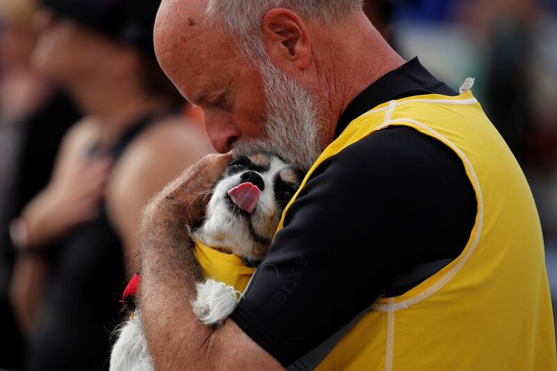 A man hugs his dog before they compete in the 14th annual Helen Woodward Animal Center "Surf-A-Thon" where more than 70 dogs competed in five different weight classes for "Top Surf Dog 2019". Reuters
