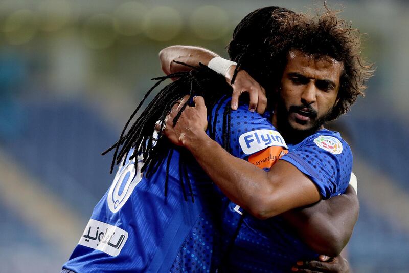 Al Hilal's player Bafetimbi Gomis, left, celebrates with a teammate after scoring against Al Hazem.