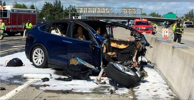 FILE - In this March 23, 2018 file photo provided by KTVU, emergency personnel work a the scene where a Tesla electric SUV crashed into a barrier on U.S. Highway 101 in Mountain View, Calif.  Tesla says, Saturday, March 31,  the vehicle in a fatal crash last week in California was operating on Autopilot, the latest accident to involve self-driving technology. The automaker says the driver, who was killed in the accident, did not have his hands on the steering wheel for six seconds before the crash. Tesla says its Autopilot feature, which can keep speed, change lanes and self-park, requires drivers to keep their eyes on the road and hands on the wheel to take control of the vehicle to avoid accidents. (KTVU via AP)