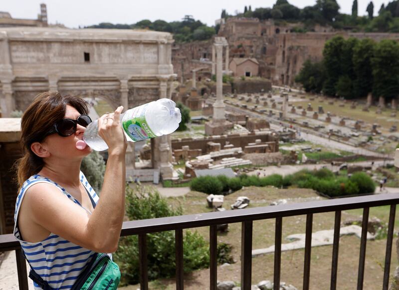 A woman drinks water near the Forum in Rome during a heatwave across Italy. Reuters