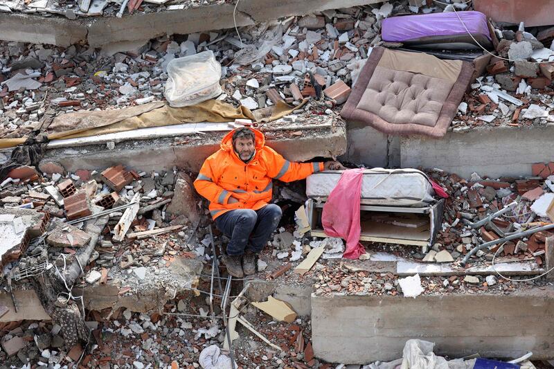 Mesut Hancer holds the hand of his 15-year-old daughter, Irmak, who died when their building collapsed during the 7.8-magnitude earthquake in Kahramanmaras, in Turkey's south-east. AFP