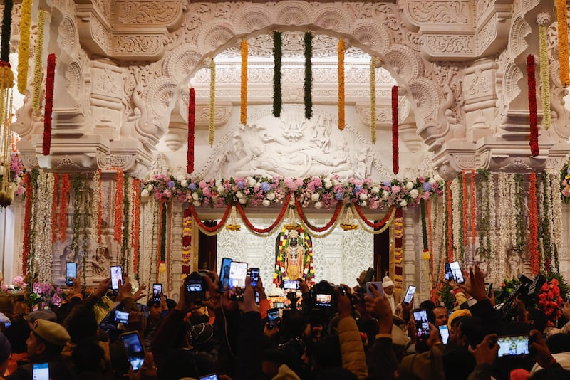 Hindu devotees take pictures of a Lord Ram idol inside the new temple in Ayodhya, Uttar Pradesh, as it opened to the public for the first time on January 23. Reuters