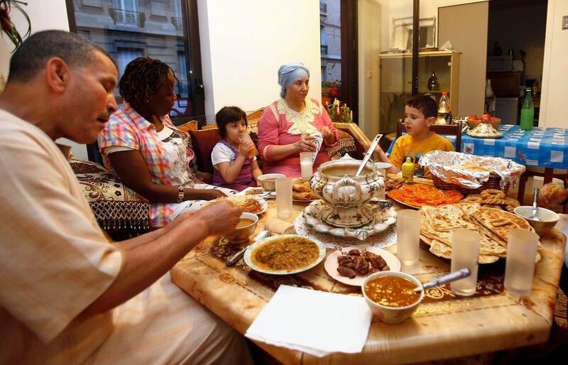 A family breaks the day's fast with the Iftar meal on the first day of the Muslim fasting month of Ramadan in Paris July 10, 2013. Muslims in France began their observance of this month of abstinence on Wednesday. REUTERS/Youssef Boudlal    (FRANCE - Tags: RELIGION FOOD) *** Local Caption ***  PARi5_FRANCE-_0710_11.JPG