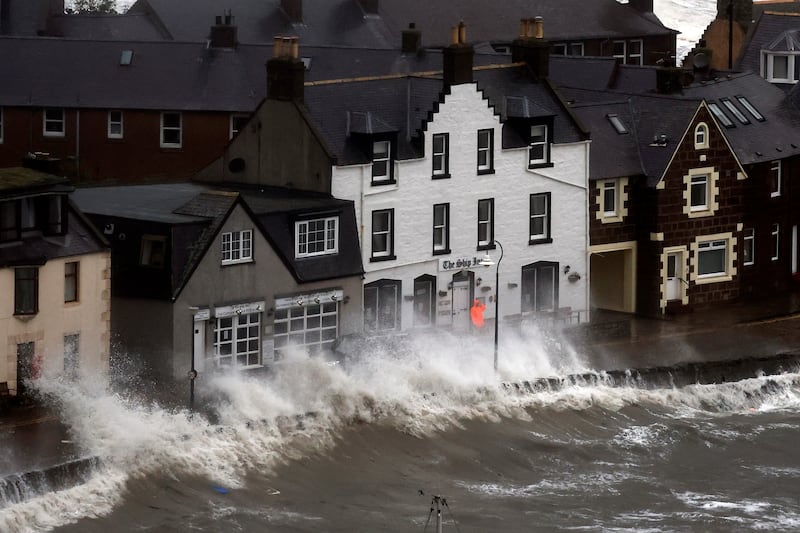 Waves crash over the harbour wall in Stonehaven. Getty 