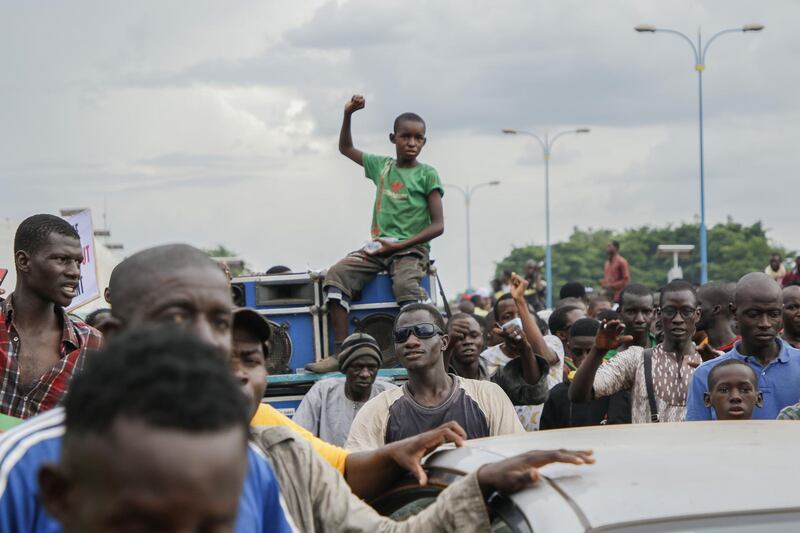 Crowds cheer as soldiers parade in vehicles along the Boulevard de l'Independance in Bamako, Mali. Getty Images