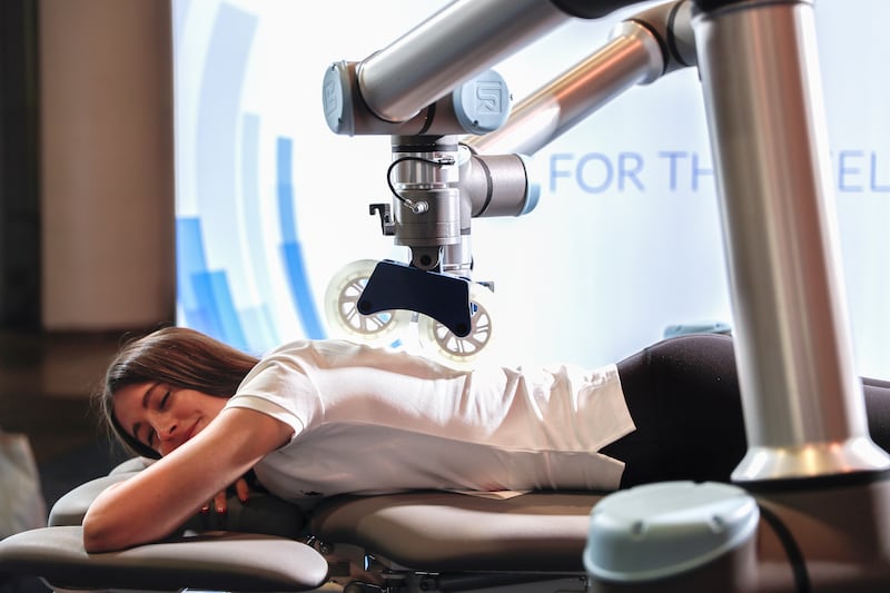 An attendee gets a robotic massage table at the Massage Robotics booth. EPA