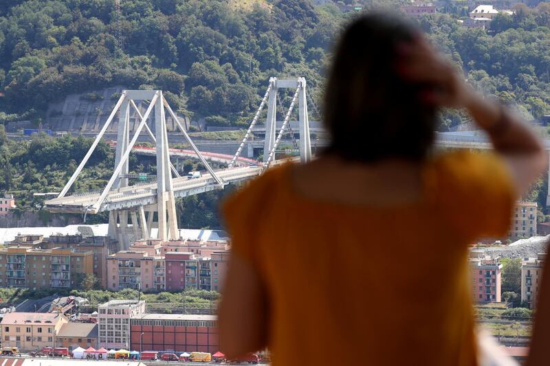 A woman look at the collapsed Morandi Bridge, in the port city of Genoa, Italy August 16, 2018.  REUTERS/Stefano Rellandini