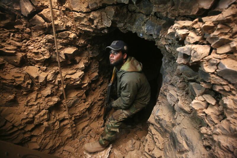 An Iraqi Shiite fighter from the Hashed Al Shaabi paramilitary forces inspects an underground tunnel in the town of Tal Abtah, south of Tal Afar, on December 10, 2016.