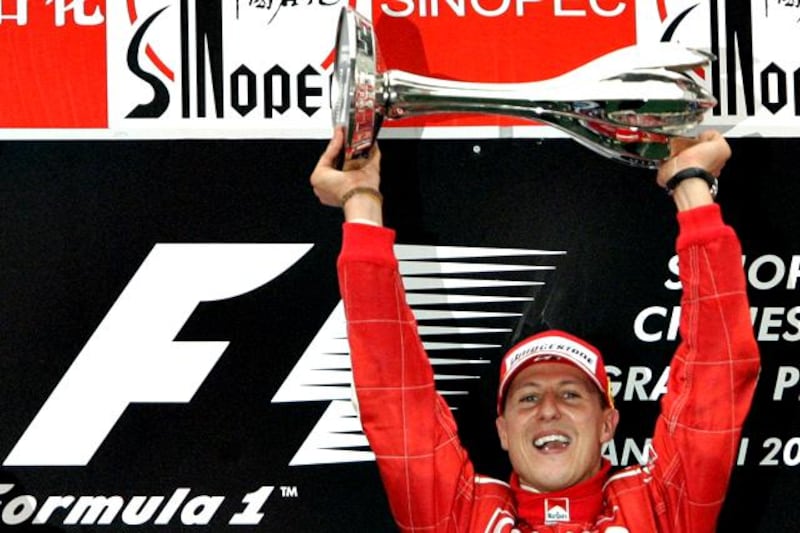 CORRECTS THE MONTH OF THE ANNOUNCEMENT  FILE - This is a   Sunday, Oct. 1, 2006. file photo  of Germany's Michael Schumacher of Ferrari as he holds the champion trophy during the award ceremony of the Formula One Chinese Grand Prix at the Shanghai International Circuit in Shanghai, China. Seven-time world champion Michael Schumacher is to retire at end of current F1 season it was announced Thursday Oct. 4, 2012. (AP Photo/Eugene Hoshiko, Fle)