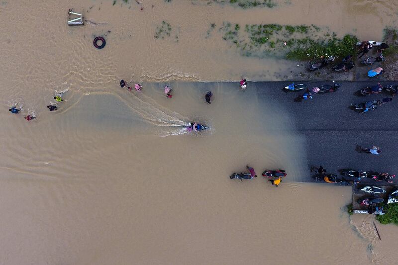 Motorists travelling in a flooded area in Matangkuli, Indonesia. AFP