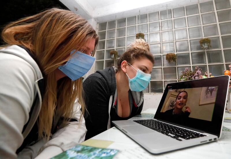 CROATIA: Two girls watch online on their computer streaming live a global concert 'One World Together at home' in Zagreb, on April 18, 2020. EPA