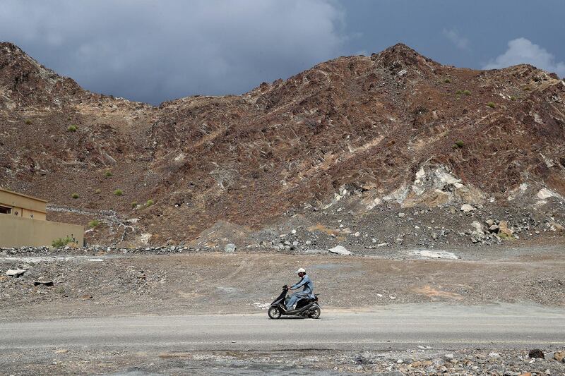 FUJAIRAH , UNITED ARAB EMIRATES ,  October 30 , 2018 :- One of the person on his scooter during the cloudy weather in the Marbad area near Masafi in Fujairah. ( Pawan Singh / The National )  For News/Standalone/Instagram/Big Picture