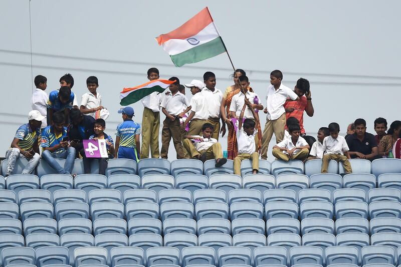 Schoolchildren wave India flags at the Maharashtra Cricket Association Stadium in Pune. AFP