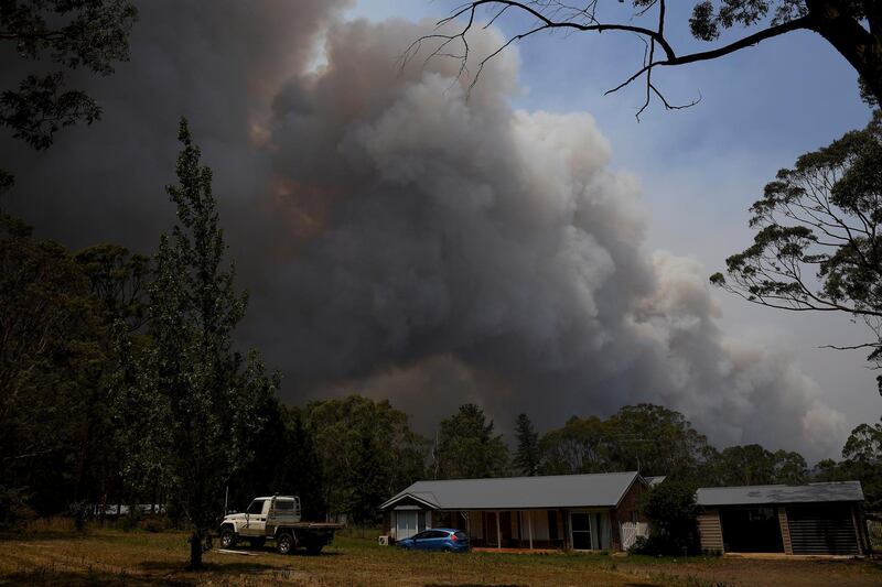 A home stands as smoke from the Grose Valley fire rises in the distance in Bilpin, west of Sydney. Reuters