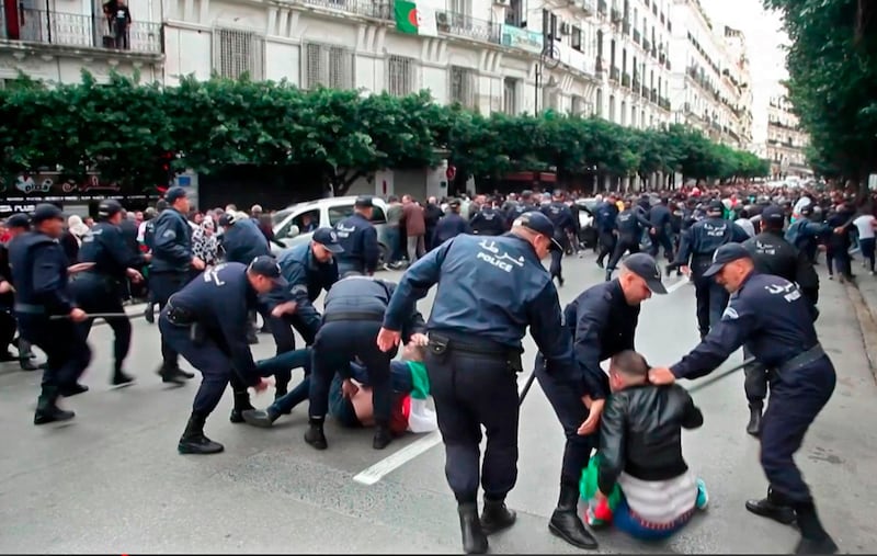 This AFPTV screen grab from a video shows Algerian security forces detaining protesters during an anti-government demonstration in the capital Algiers on the day of the presidential election. About 10,000 protesters rallied in Algeria's capital against presidential elections they believe aim to perpetuate the regime of deposed leader Abdelaziz Bouteflika, AFP reporters witnessed. The crowd outnumbered police who had intervened with force and made several arrests in a bid to prevent a mass demonstration of the almost 10-month old "Hirak" protest movement. AFP