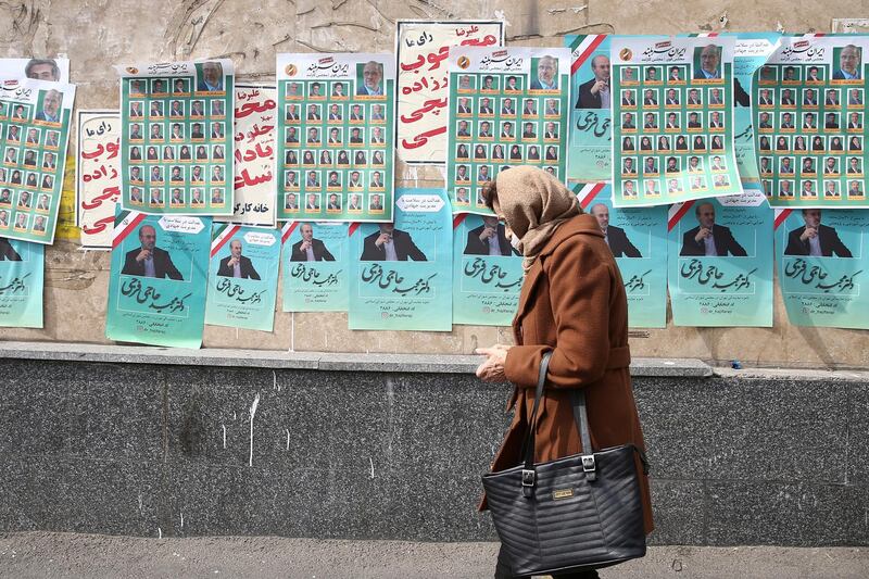 A woman walks past parliamentary election campaign posters in Tehran. Reuters