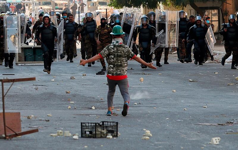 Iraqi protester confronts security forces at the Shuhada Bridge in central Baghdad AP Photo