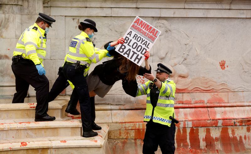 Police officers detain an Extinction Rebellion activist during a protest outside Buckingham Palace. Reuters