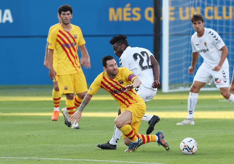 Lionel Messi is challenged by Thomas Amang during Barcelona's pre-season friendly against Gimnastic. Reuters