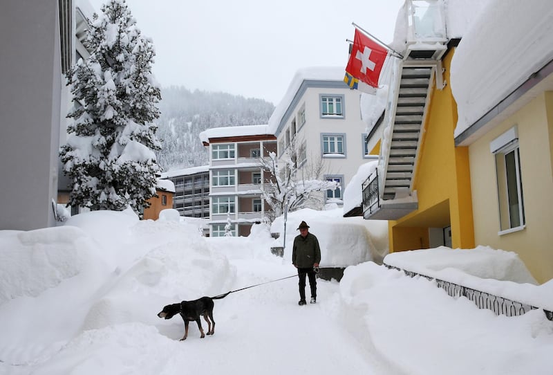 A man walks his dog after a snowfall ahead of the World Economic Forum (WEF) annual meeting in the Swiss Alps resort of Davos. Denis Balibouse / Reuters