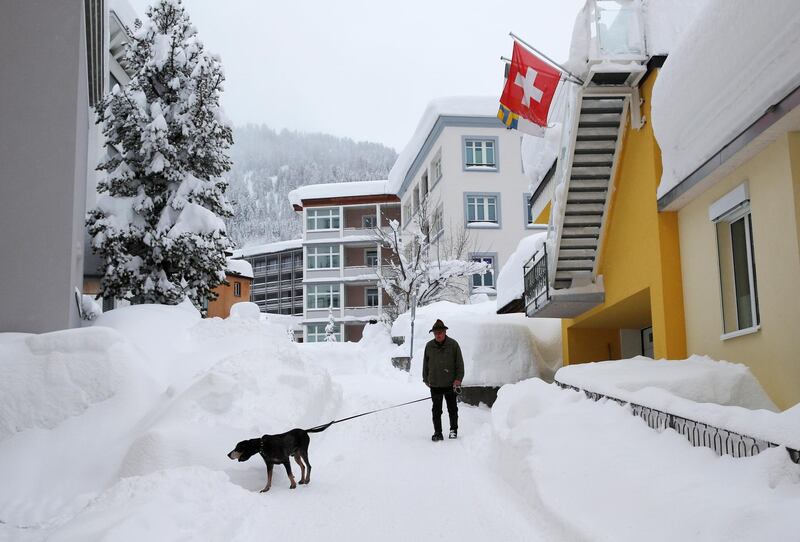 A man walks his dog after a snowfall ahead of the World Economic Forum (WEF) annual meeting in the Swiss Alps resort of Davos. Denis Balibouse / Reuters