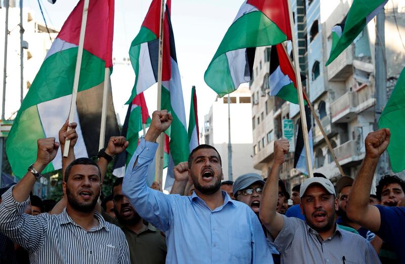 Protestors wave Palestinian flags while chanting anti-Israeli slogans during a protest against a march by Jewish ultranationalists through east Jerusalem, along the streets of Gaza City. AP Photo