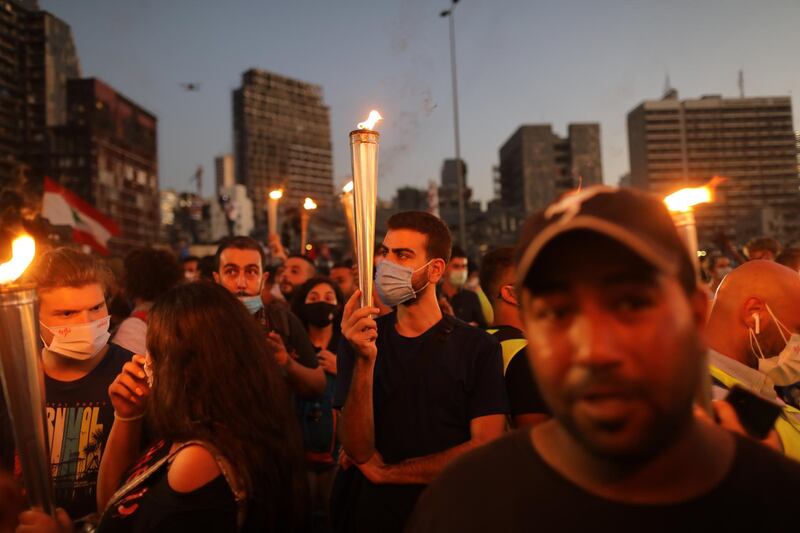 People hold Lebanese flags and lit candles to mark the first anniversary of anti-government protests. Getty Images