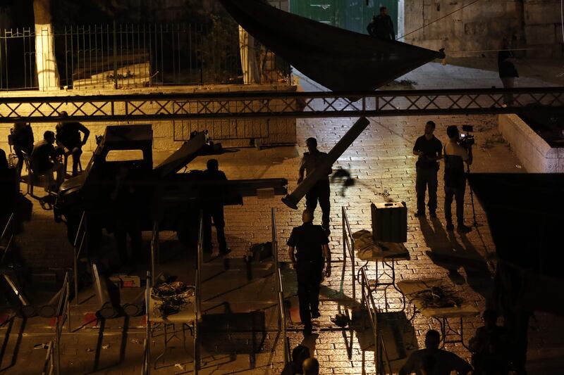 Israeli security forces take down security barriers at the Lions' Gate, a main entrance to the Al-Aqsa mosque compound in Jerusalem's Old City, on July 24, 2017.
Jordan's King Abdullah II urged Israeli Prime Minister Benjamin Netanyahu to remove new security measures at an ultra-sensitive Jerusalem holy site. / AFP PHOTO / Ahmad GHARABLI