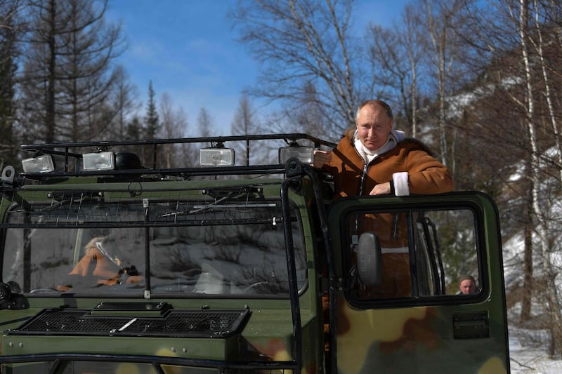 Russian President Vladimir Putin poses for a photograph in an all-terrain vehicle, during his holiday in Siberian taiga forest. AFP