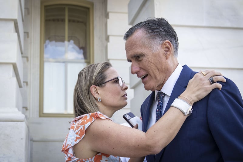 Kyrsten Sinema, a Democratic senator from Arizona, speaks with Utah's Mitt Romney outside the US Capitol. AFP