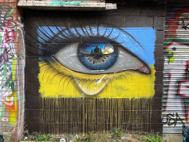 Street artist MyDogSighs's mural in Northcote Lane, Cardiff of a weeping eye in the colours of the Ukrainian flag. PA