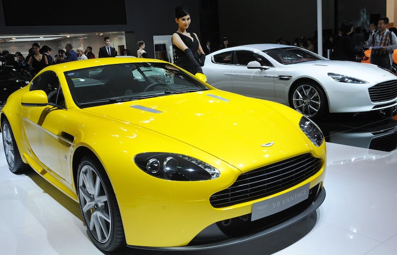 This photo taken on April 20, 2013 shows a model posing next to a Aston Martin V8 Vantage on media day at the Shanghai auto show. The Shanghai auto show, which opens to the public on April 21, is expected to attract more than 800,000 visitors over the course of nine days.     AFP PHOTO / Peter PARKS
 *** Local Caption ***  957200-01-08.jpg