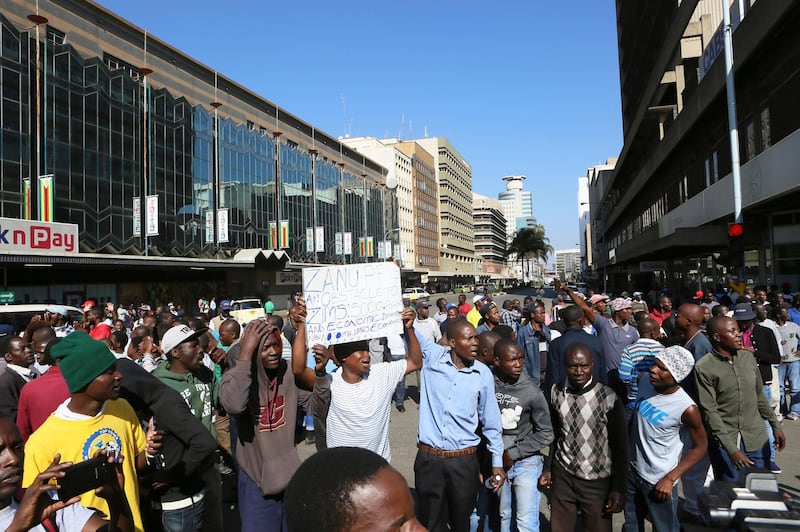 Protestors gather on a street in Harare. AP Photo