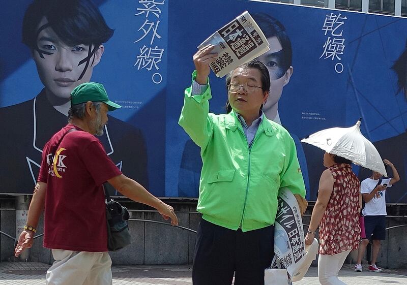 A staff of a Japanese newspaper hands out passer-by an extra newspaper reporting North Korea's rocket launch at a shopping street in Tokyo Tuesday, August 29, 2017. Mari Yamaguchi / AP Photo